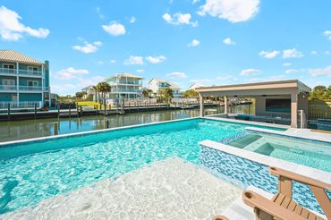 Wide view of private pool and outdoor living area overlooking the canal at Serenity Cove