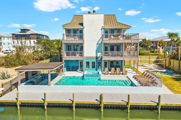 Full rear view of Serenity Cove luxury vacation home with pool and dock in Perdido Key