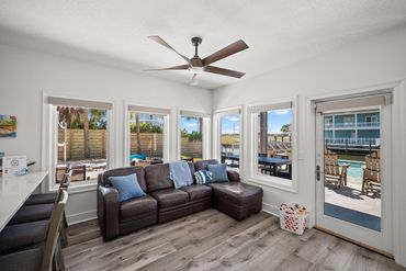 First floor lounge area with leather sectional and pool views at Serenity Cove FL