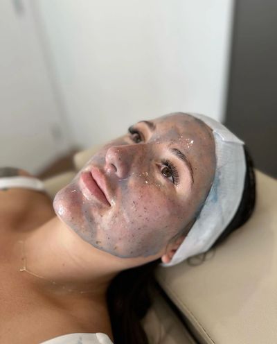 Woman relaxing with a facial mask and headband.