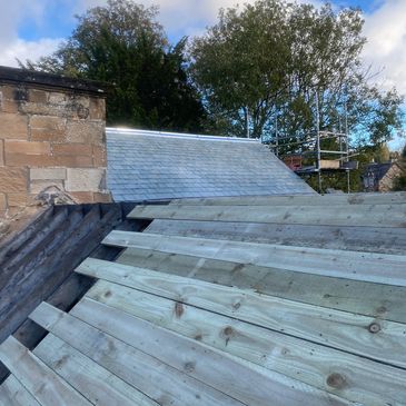 Domestic roof under repair with slates 