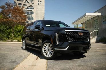 A sleek black Cadillac SUV parked outdoors on a sunny day.