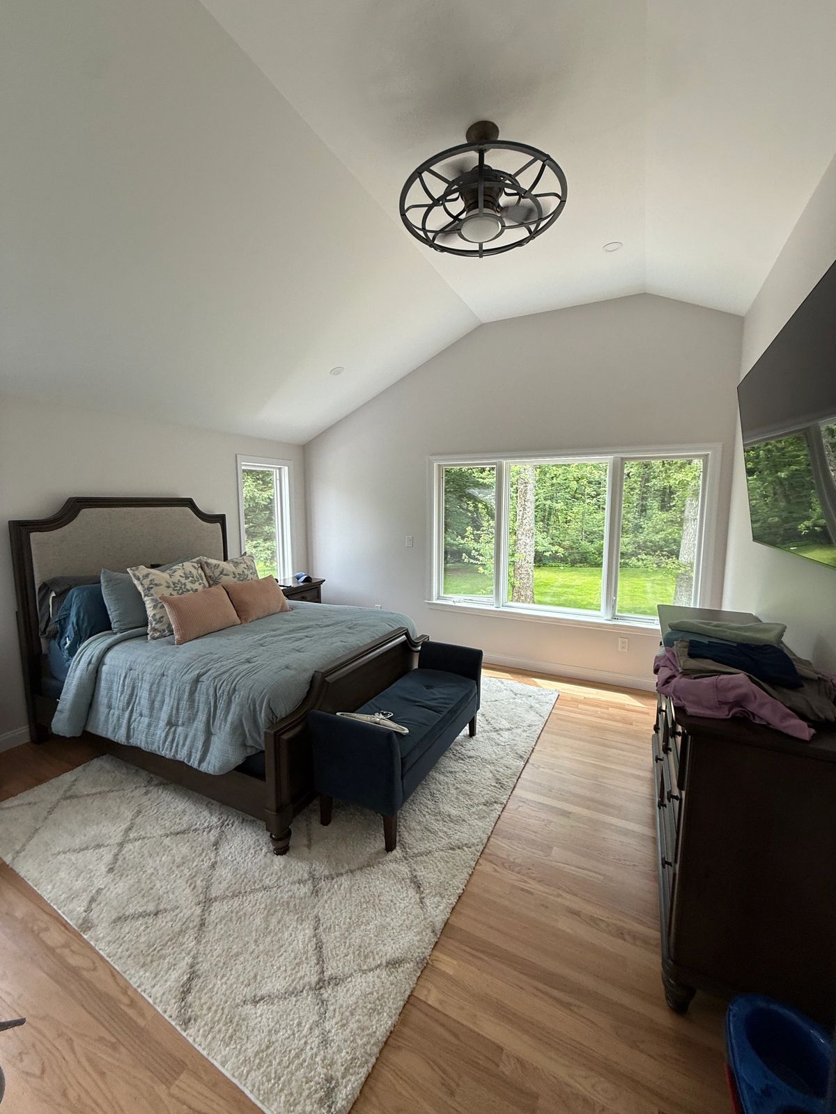 Bedroom with a vaulted ceiling, hardwood floor and large windows