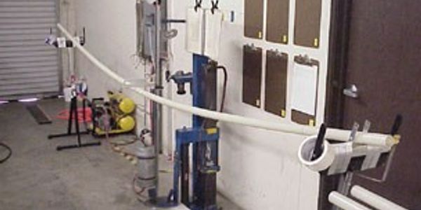 Indoor industrial workspace with pipes and equipment.