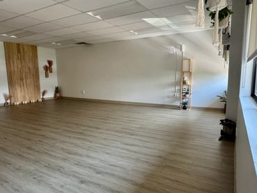 Spacious, minimalistic room with wooden floor and natural light.