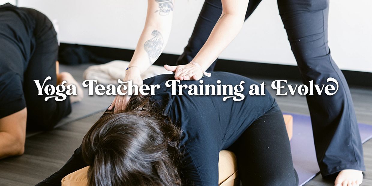Yogi in a supported position while instructor provides a gentle hands-on assist on her back