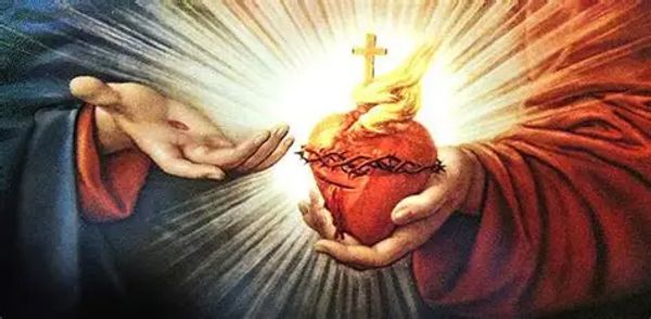 Hands holding the Sacred Heart of Jesus with a glowing cross above it.