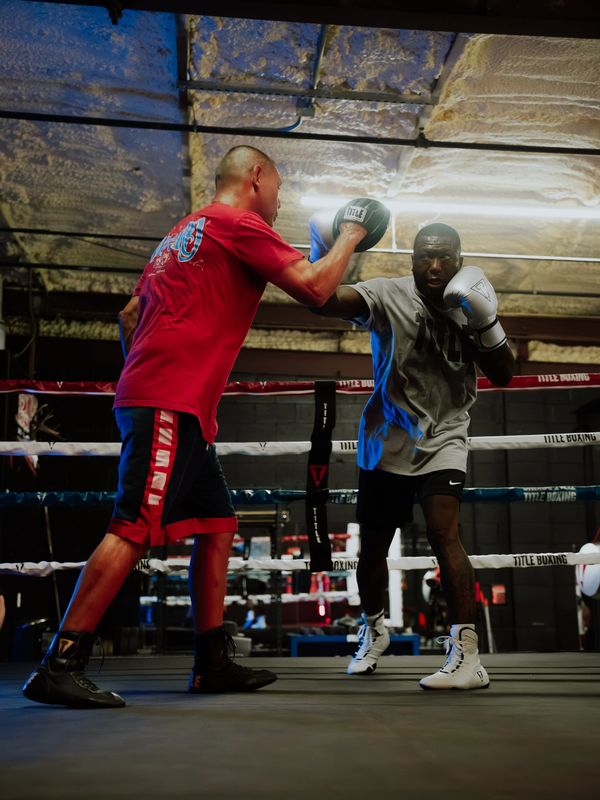 Two men boxing in a gym ring.