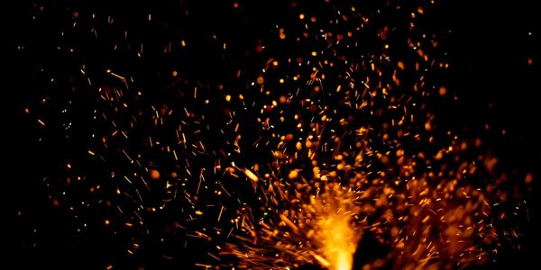Bright orange sparks flying against a black background.