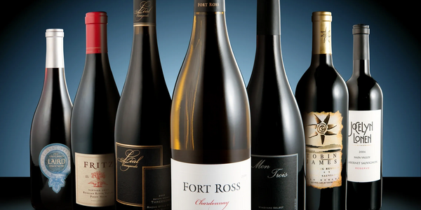 Seven assorted wine bottles arranged in a row with a blue gradient background.