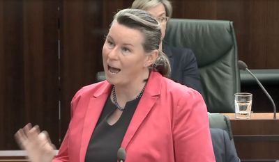 Woman speaking passionately in a formal setting.