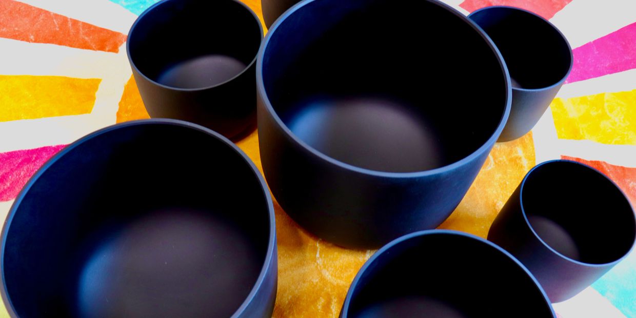 Set of black nesting bowls on a colorful surface.