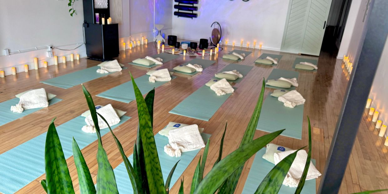 Yoga mats and towels neatly arranged in a calming room with candles.
