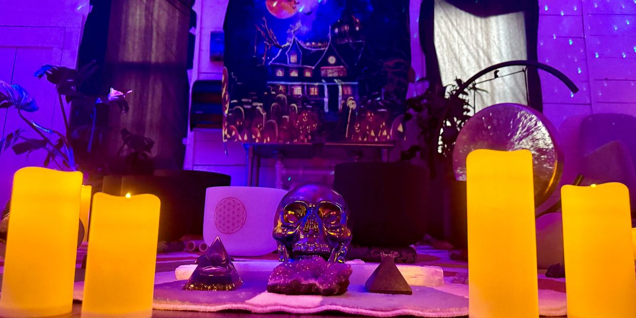 Spooky altar with skull, candles, and glowing purple ambiance.