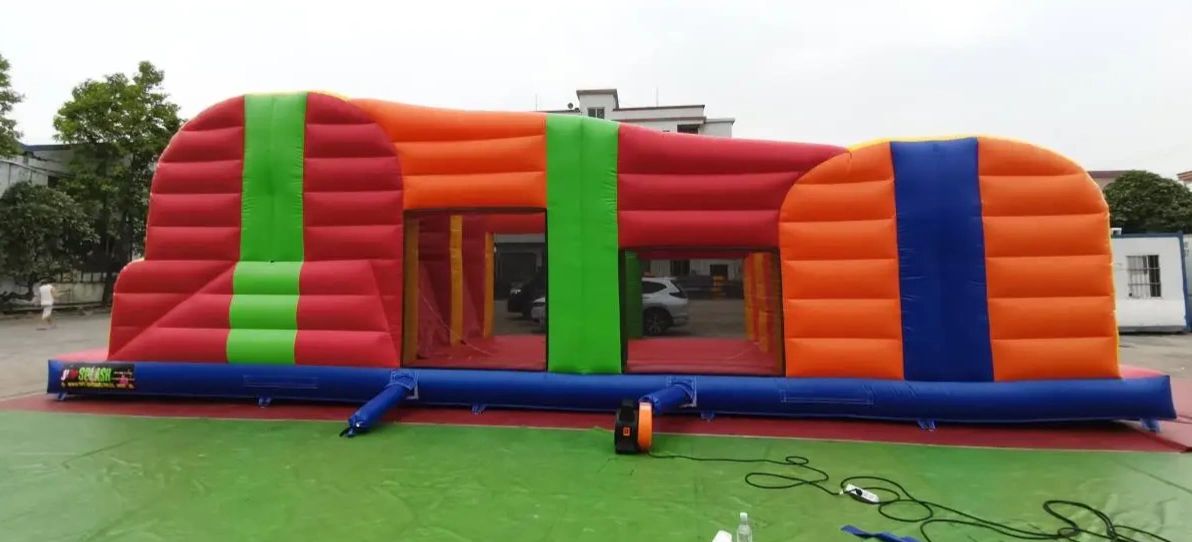 Colorful inflatable bounce house with red, orange, green, and blue sections.