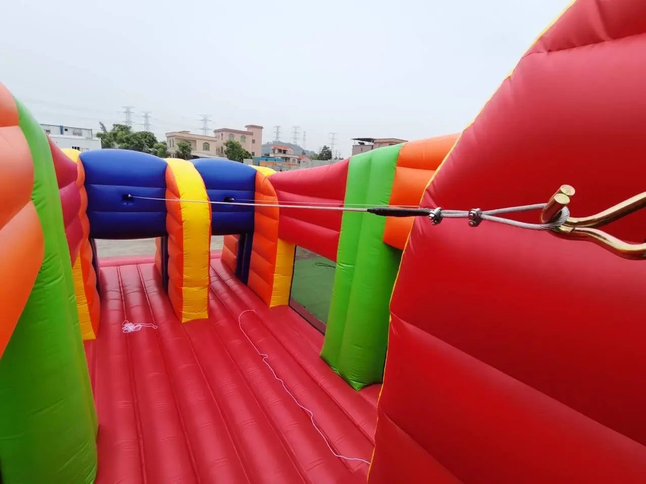 Colorful inflatable structure with a zip line inside.