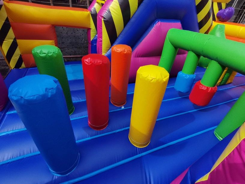 Colorful inflatable obstacle course with various vertical pillars and barriers.
