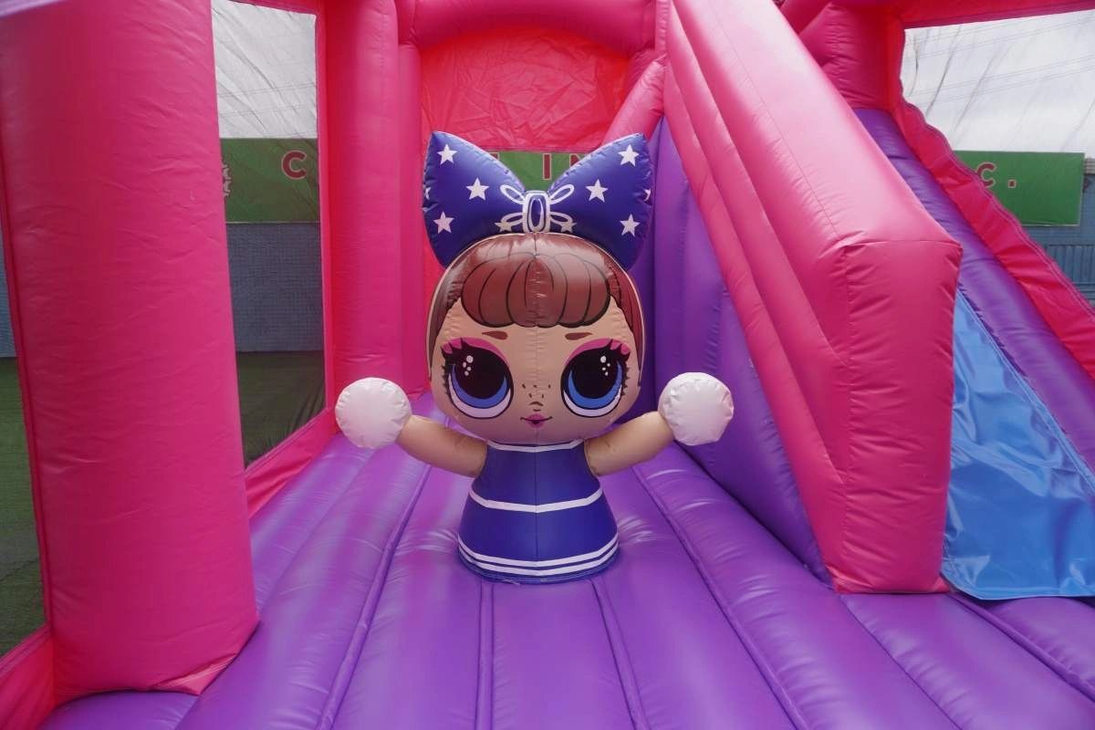 Colorful inflatable play area with a large doll figure inside.