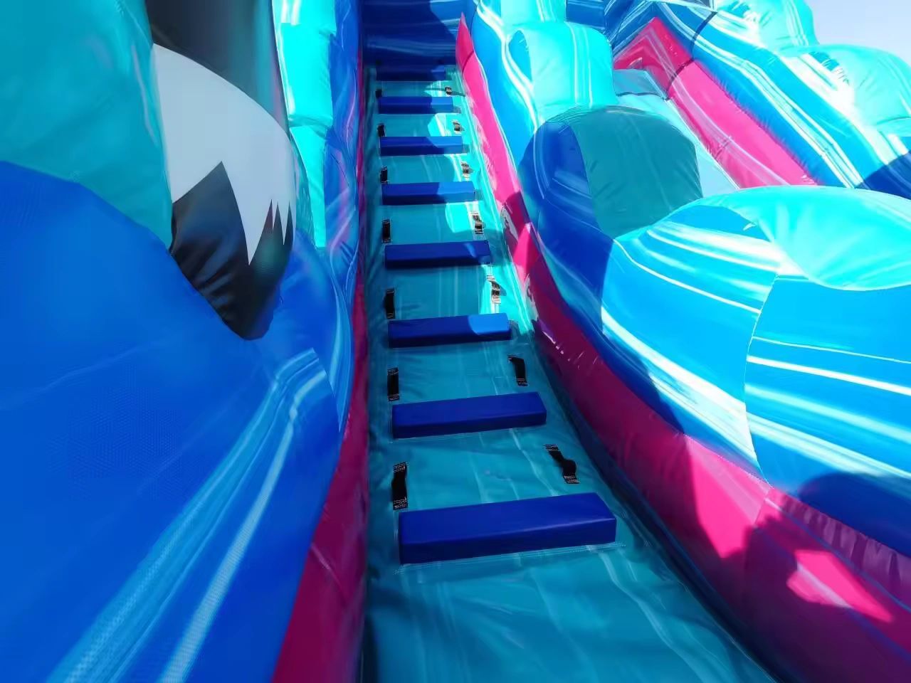 Colorful inflatable slide ladder with blue steps and vibrant accents.