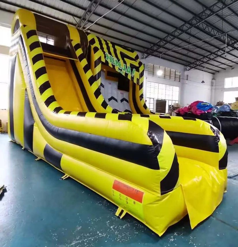 Large yellow and black inflatable slide in an indoor setting.