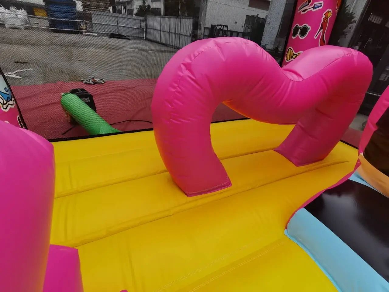 Bright inflatable playground with pink and yellow colors outdoors.