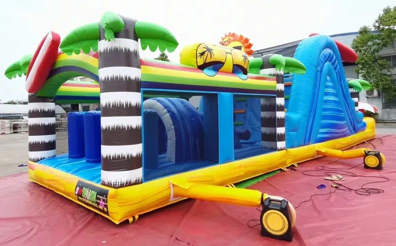 Colorful inflatable obstacle course with palm tree and sun designs.