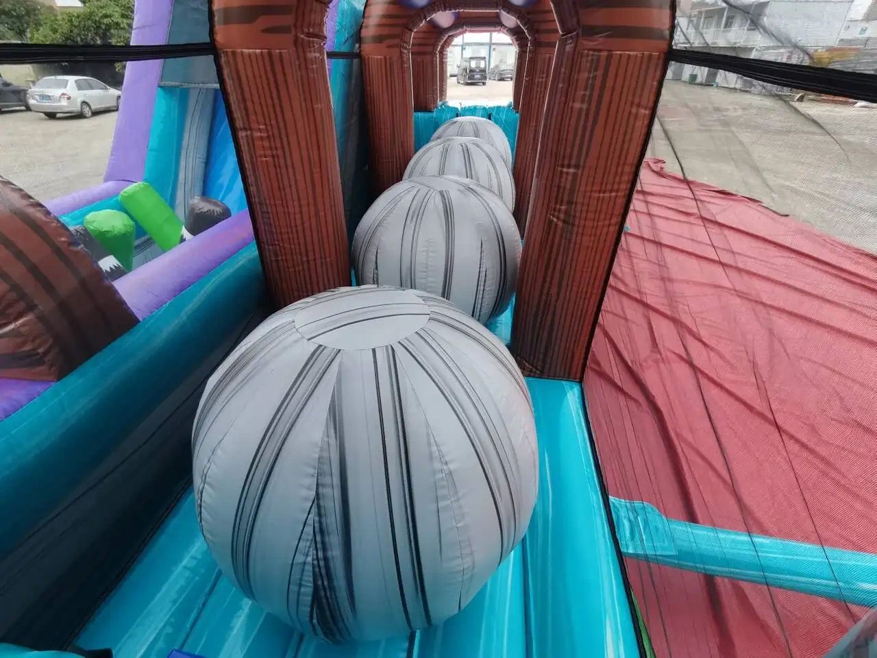 Inflatable obstacle course with large striped balls inside.