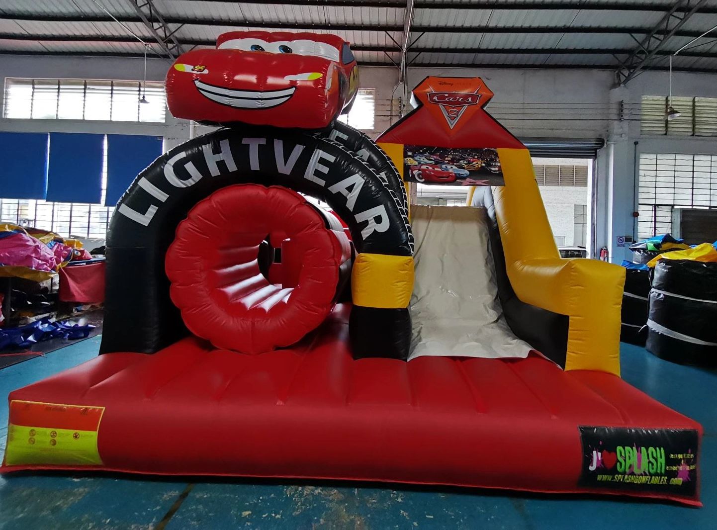 Inflatable slide and obstacle course themed with Cars movie character Lightning McQueen.