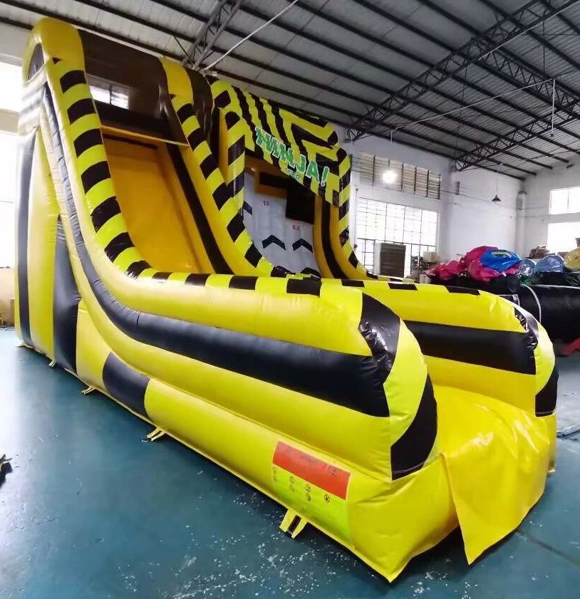 Large yellow and black inflatable slide indoors.