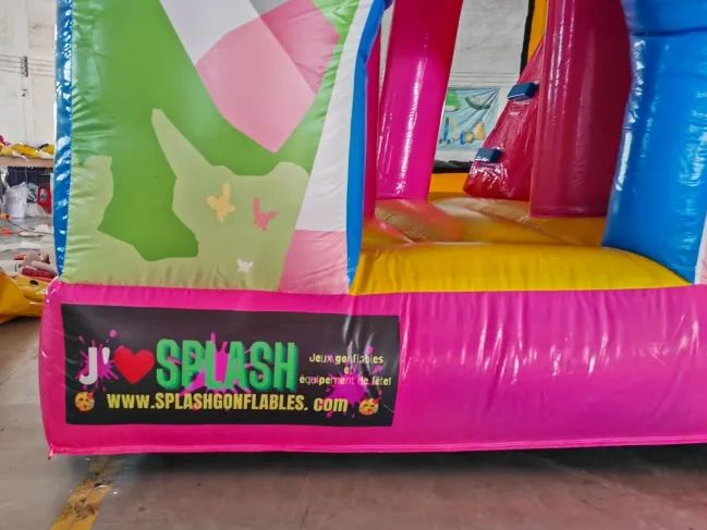 Colorful inflatable play structure with advertising banner at the bottom.