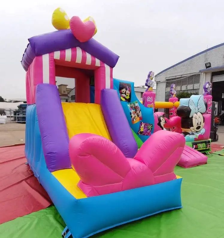 Colorful inflatable slide with a heart and bow decoration, featuring cartoon characters.