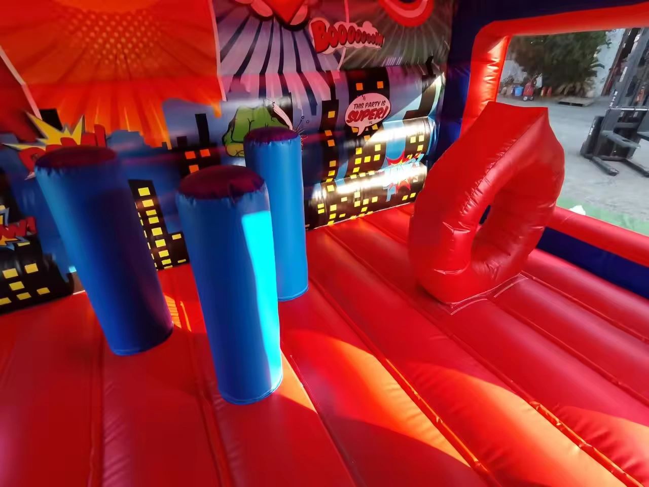 Colorful inflatable bounce house with comic-style decorations and obstacles.