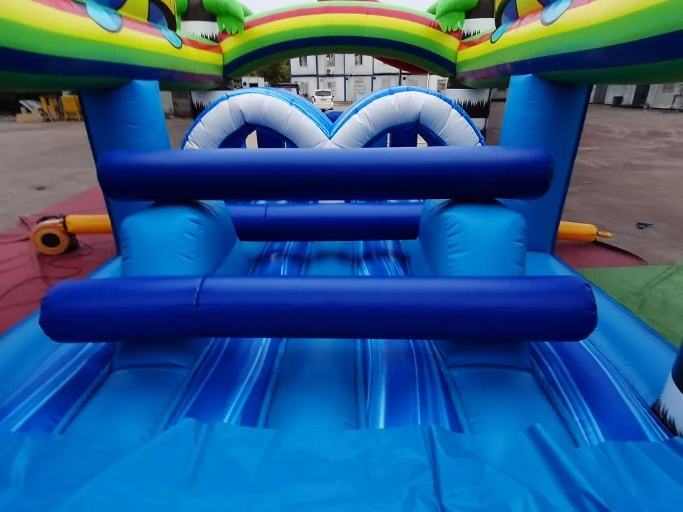 Colorful inflatable obstacle course with blue, green, and rainbow elements.