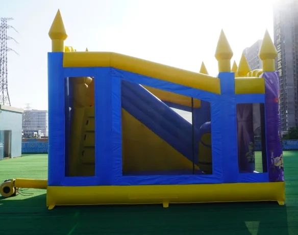 Inflatable blue and yellow bounce house with slide on green turf.