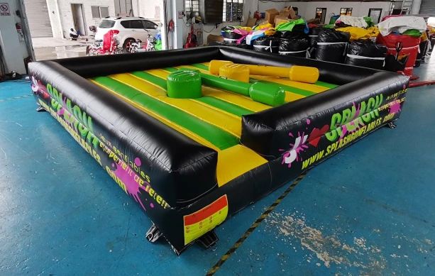 Inflatable game arena with yellow and green stripes indoors on a blue floor.