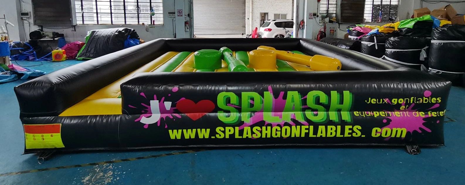 Inflatable game arena with colorful obstacles indoors.