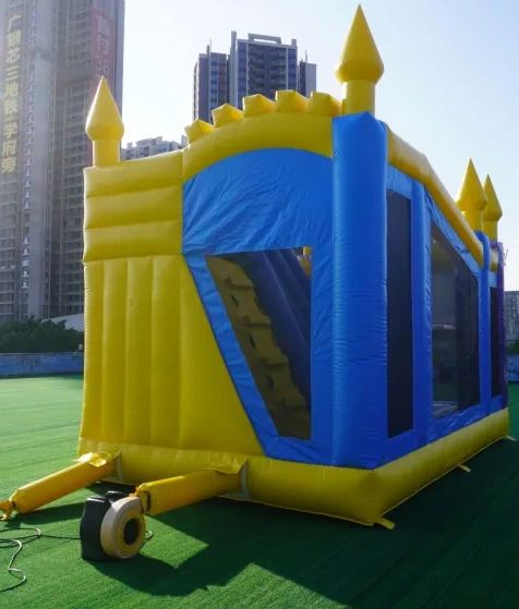 A yellow and blue inflatable bounce house shaped like a castle outdoors.