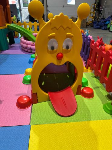 Colorful indoor playground with a playful character slide.