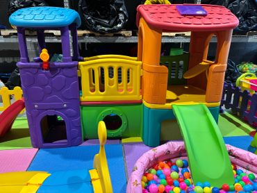 Colorful indoor playground with slides and a ball pit for children.