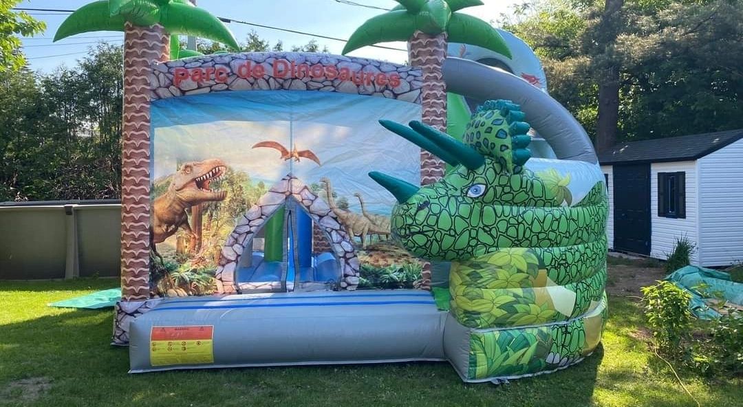Inflatable dinosaur-themed bounce house in a sunny backyard.