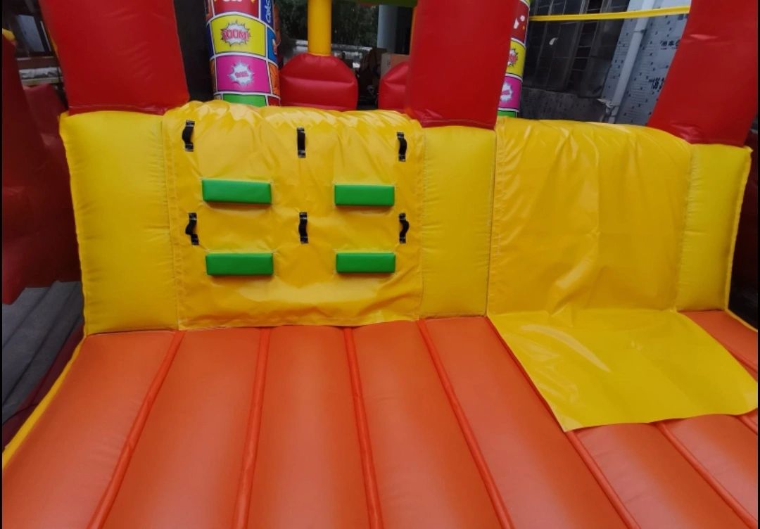 Close-up of colorful inflatable play structure with yellow and orange sections.