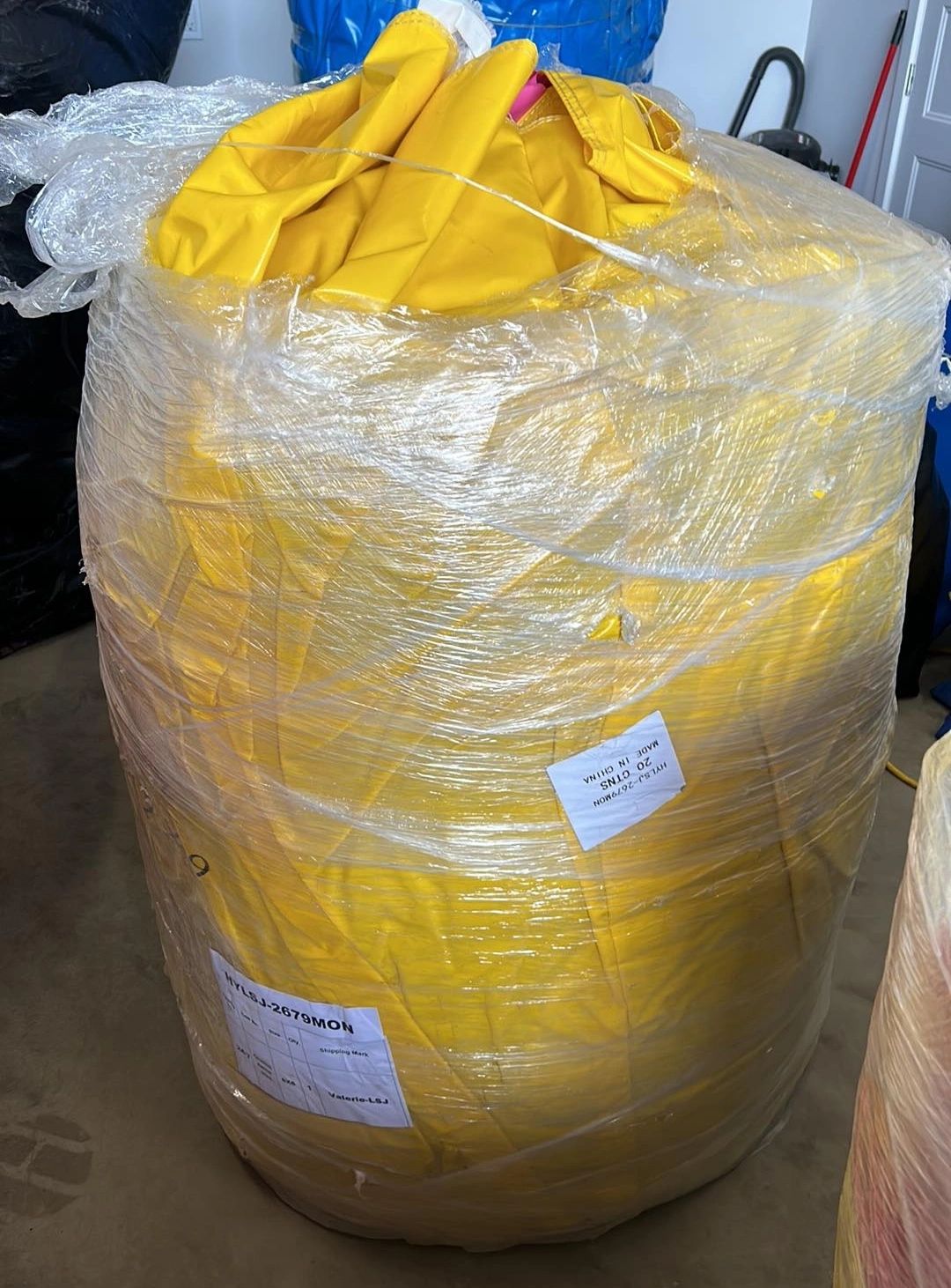 Large bundle of yellow fabric wrapped in plastic with labels attached.