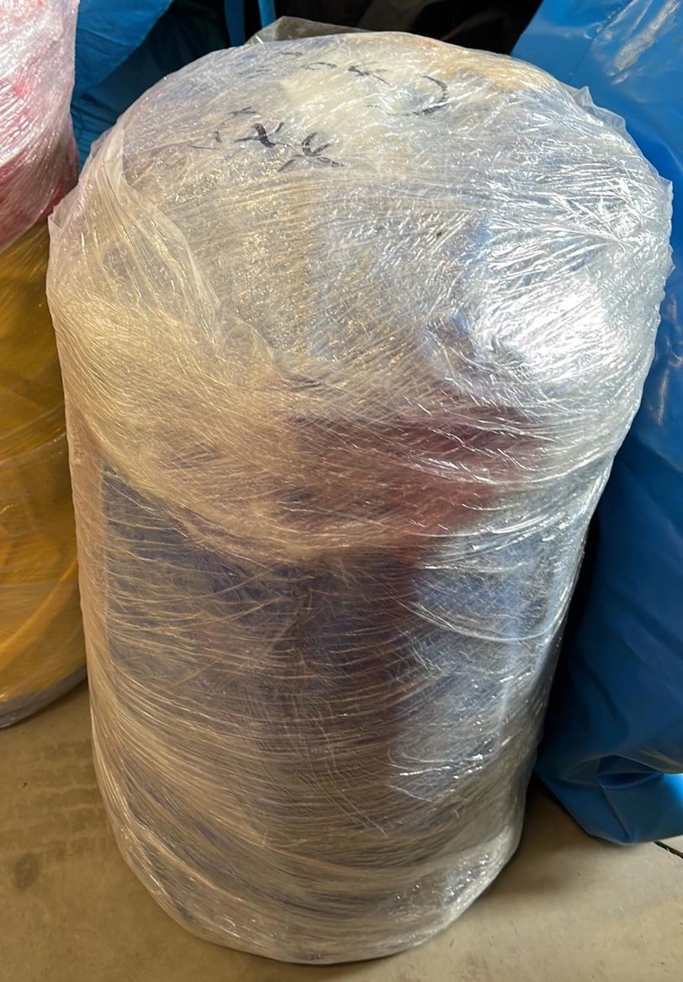 Large bundle wrapped tightly in clear plastic wrap.