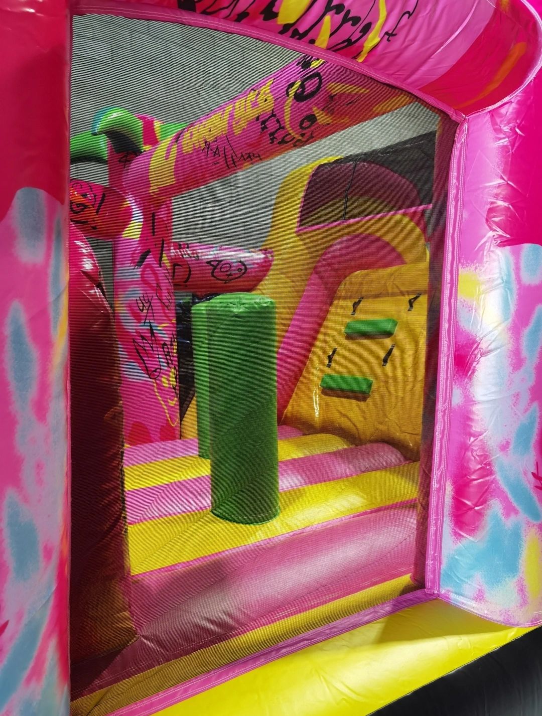 Colorful inflatable bounce house with slides and obstacles for kids.