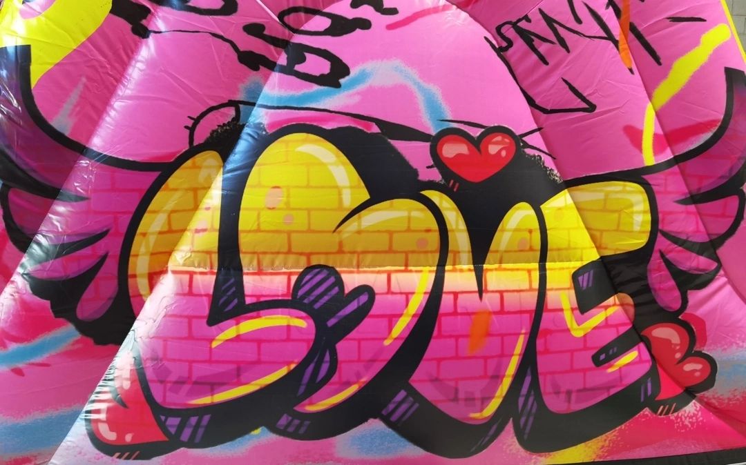 Colorful graffiti art spelling 'LOVE' with vibrant hearts and wings.