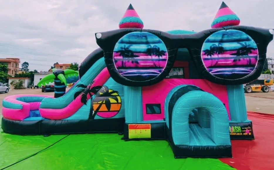 Colorful inflatable bounce house with sunglasses and tropical design.