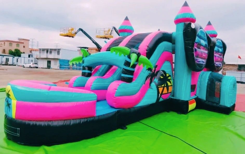 Colorful inflatable bounce house with tropical palm tree designs.