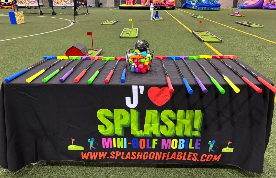 Colorful mini-golf clubs and balls set up on a promotional table for Splash! Mini-Golf Mobile.