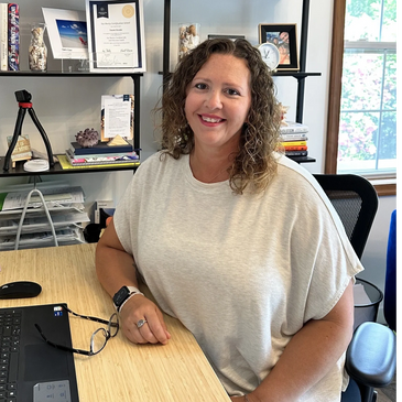 Naomi Kreske sitting at her desk smiling