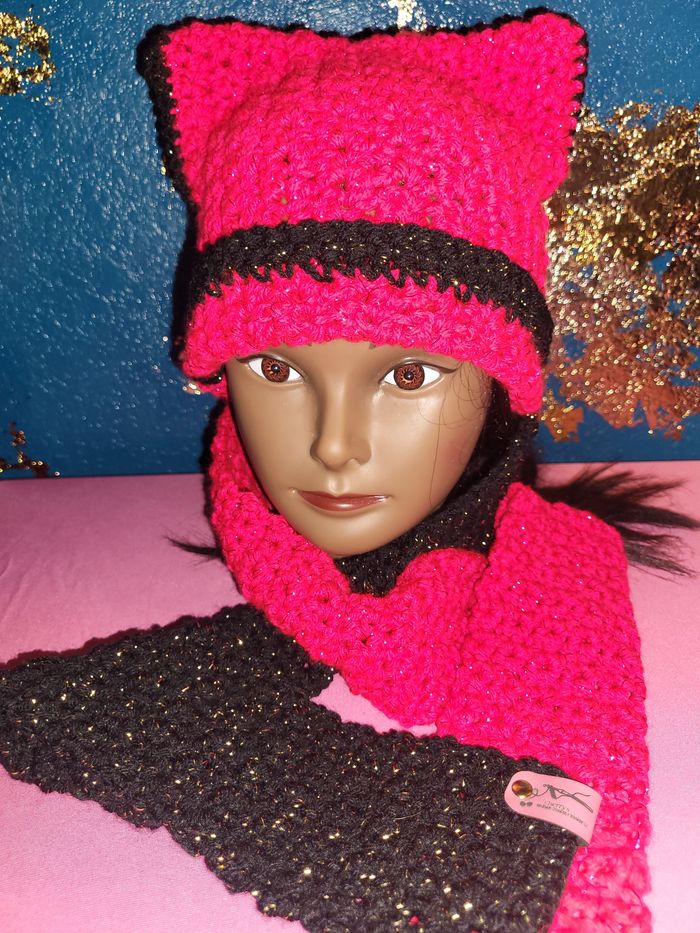 Mannequin wearing a handmade pink and black knitted hat and matching scarf.